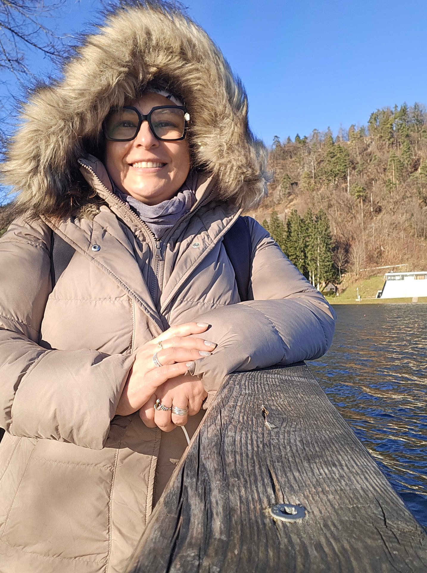 Fabiana Albertin sorrindo à beira de um lago na Europa